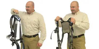 A worker is shown in two side-by-side images, first holding the harness by the back D-ring, and then bending to put his arms through the shoulder straps. This process is like putting on a vest, ensuring the back pad and D-ring are correctly positioned between the shoulder blades.