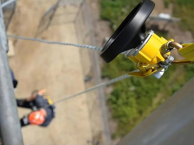 This image shows a yellow automatic or user-controlled device used to lower a worker down a rope from a great height. These specialized devices help either lower workers to safety or raise a fallen worker when a rescue is necessary.